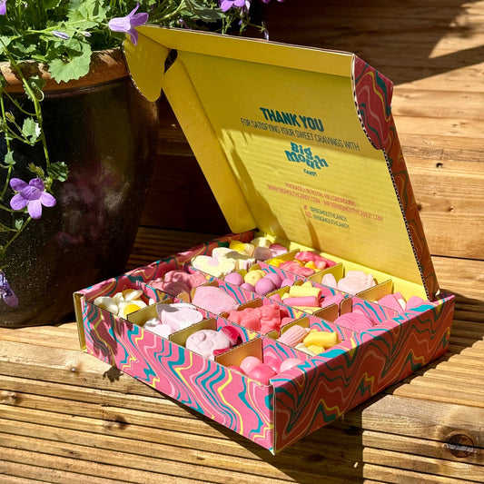 Big Mouth Candy 1KG pick and mix sweet box with colourful fizzy and gummy sweets in sectioned packaging, perfect gift idea for sweet lovers, photographed outdoors in natural light.