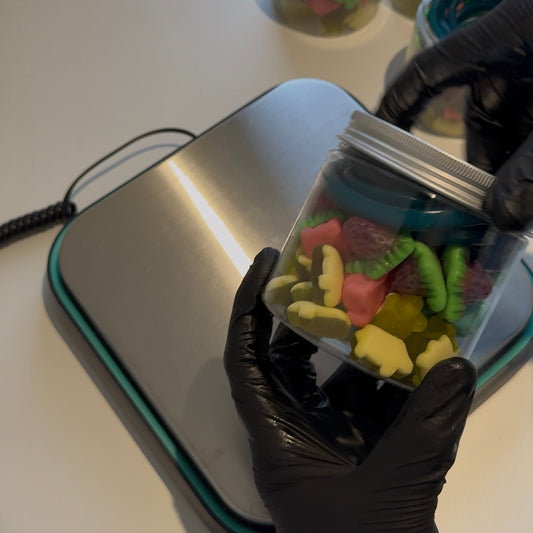 Video of Big Mouth Candy jar being packed with colorful pick-and-mix sweets including gummy strawberries, foam animals, jelly strawberries, and blue pencils – perfect for sweet lovers and gift hampers.