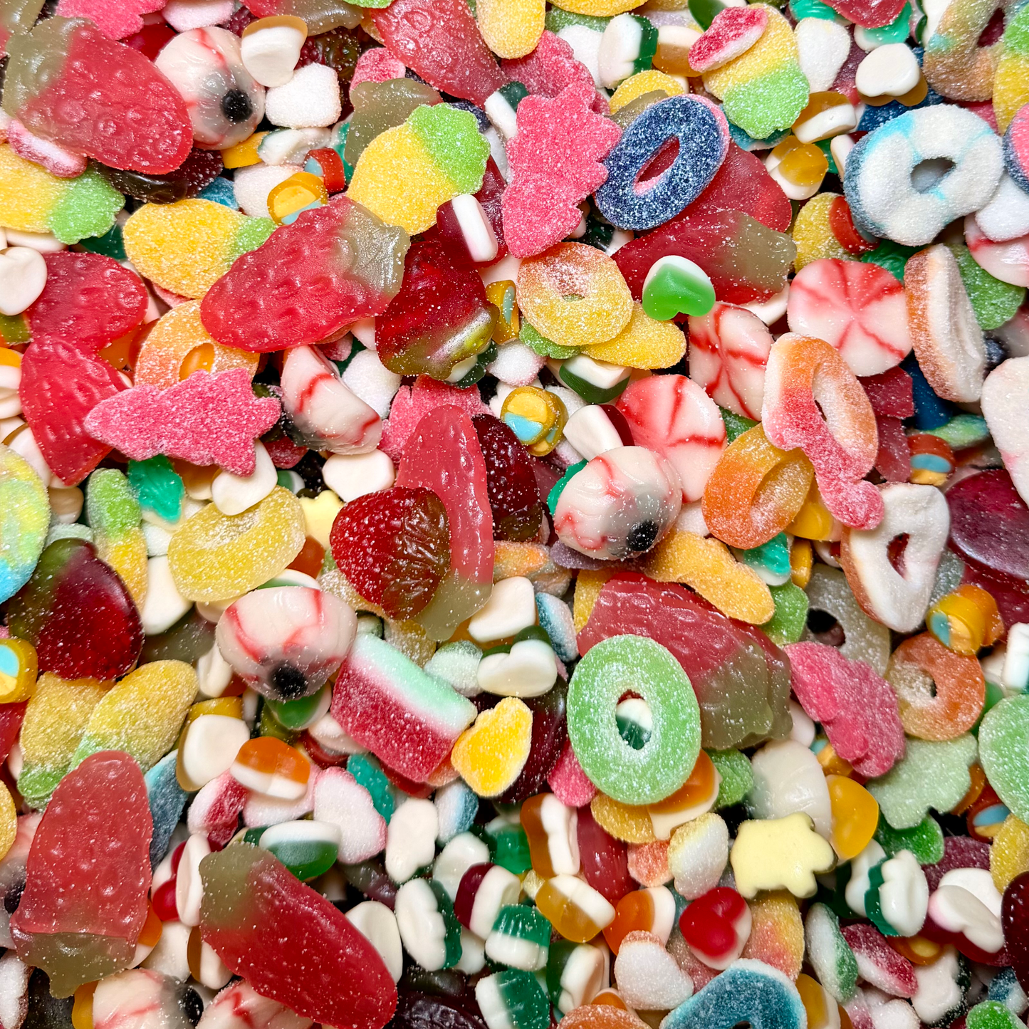 Close up of jelly and fizzy pick and mix sweets showing soft textures and sugar coated sour sweets
