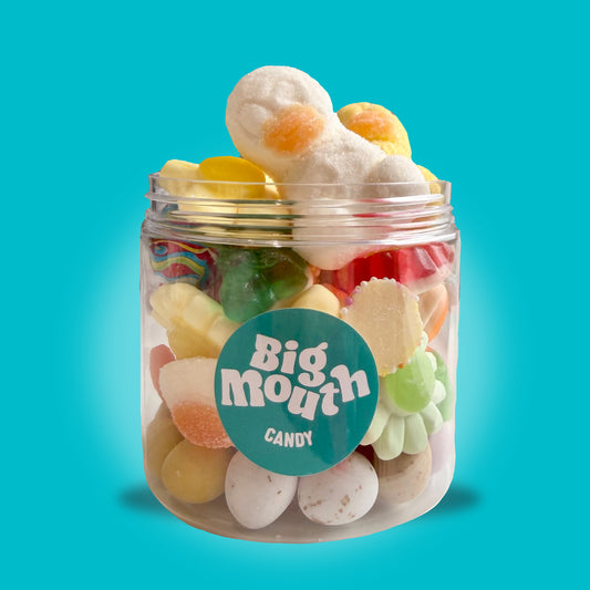 Spring Treats Jar 210g from Big Mouth Candy filled with mini eggs, jelly sweets, bunny sweets and marshmallow treats in a clear jar on a blue background